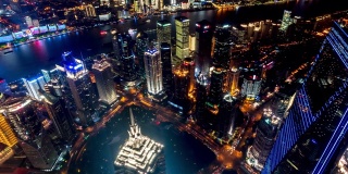 4k时间推移:航拍上海陆家嘴区和外滩全景，摩天大楼灯光秀在晚上，中国。