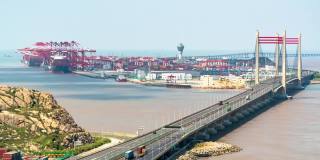 4K时间推移:鸟瞰图的自动化工业港与货船和集装箱卡车在桥上。