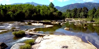 石在流河中，与树木和山丘景观