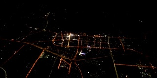 飞过夜晚的城市。俯视图的现代大都市