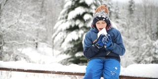 可爱的小男孩在冬天吃雪