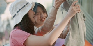 两个年轻的亚洲女人在地铁上展示她们在购物袋里买的新东西，慢镜头
