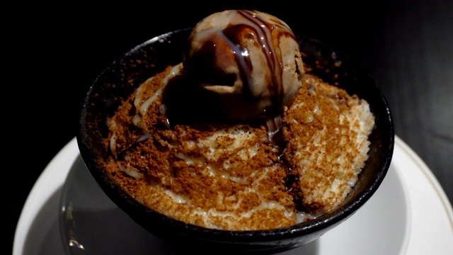 美味的甜黑巧克力冰酥或刨冰放在旋转杯中，准备放在桌上吃