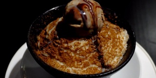 美味的甜黑巧克力冰酥或刨冰放在旋转杯中，准备放在桌上吃