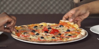 两只手拿一片披萨。人们在吃意大利菜。饮食概念