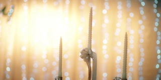 白色蜡烛与复古烛台在室内，以明亮的白焦背景。