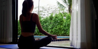亚洲女性以苗条的身材在家练习瑜伽，积极健康的生活方式理念