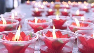 桌上放着红莲花蜡烛。祈祷好运。中国新年。中国的寺庙。视频素材模板下载