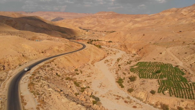 沙漠山丘上的高速公路，用无人机拍摄。空旷的公路，美丽的自然景观。中东沙漠中的国王公路。