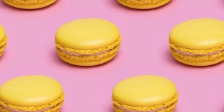 图案与黄色的马卡龙饼干在粉红色的背景。