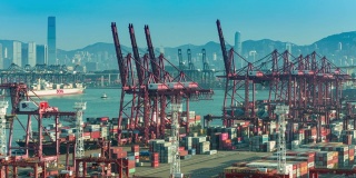 4K时间推移:码头商业港口和吊车桥装载集装箱到集装箱船与香港城市景观背景。