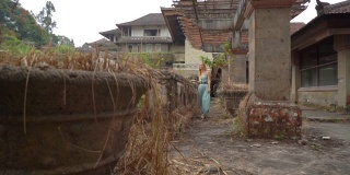 Slowmotion射杀。一名年轻女性游客参观了被遗弃的神秘旅馆。印度尼西亚,巴厘岛。巴厘岛旅游的概念