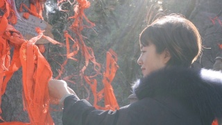 中国陕西庙里，女子在木棍上系红丝带。视频素材模板下载