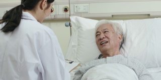 年轻的亚洲医疗工作者与老人交谈