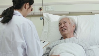 年轻的亚洲医疗工作者与老人交谈视频素材模板下载