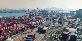4K时间延时:码头商埠的集装箱货物仓库和工作吊车桥装卸集装箱，以城市景观为背景的商务物流、进出口、航运或运输