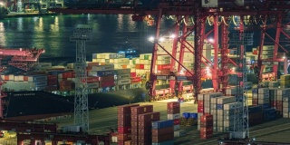 4K延时:工作吊桥在夜间将集装箱装到集装箱船，用于商业物流，进出口，运输或运输。