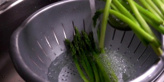 煮熟的绿芦笋落入冷水中