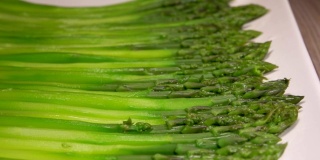 绿色的芦笋放在一个长长的白色盘子里