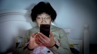 老年妇女躺在床上打电话视频素材模板下载