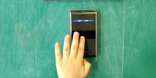 特写的一个孩子的手打开一个自动门与触摸键。