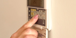 壁挂式空调遥控，可调节室内温度。特写镜头