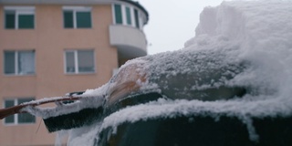 在雪地里开车。年轻女子在第一场雪后清理汽车。