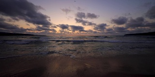 热带海滩和美丽的大海日出。戏剧性的云和舞动的海浪