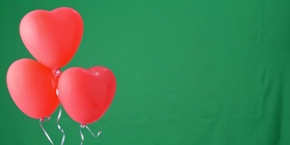 红色心形氦气球孤立在绿色屏幕背景上，情人节、生日派对的设计理念