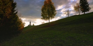 摄影师在日落时拍摄田野里孤独的树。美丽的斯洛文尼亚景观