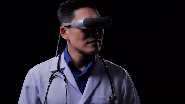亚洲男医生戴着虚拟现实眼镜看测试结果与模拟器界面上的黑色背景。成功，未来，技术，创新，医学，医院，科学，教育主题，领导力，虚拟现实，医疗技术概念。