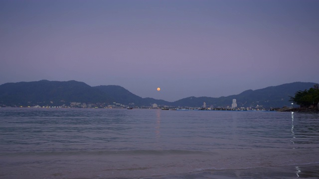 从有小波浪和平静的大海的沙滩上俯瞰城市