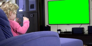 情绪激动的女孩子看着绿屏色度键电视