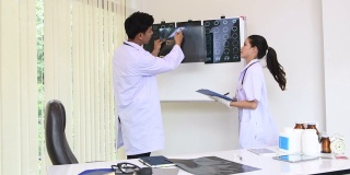年轻男女外科医生与同事一起讨论和回顾x光影像