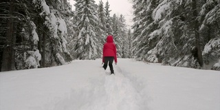 在白雪覆盖的森林里跳跃的女人