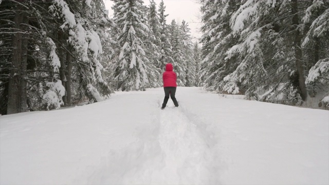 在白雪覆盖的森林里跳跃的女人