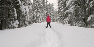 在白雪覆盖的森林里跳跃的女人