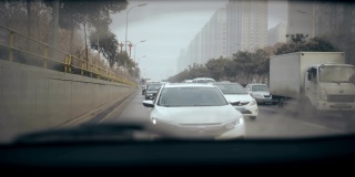 女子在高速公路上行驶，从汽车后窗观看