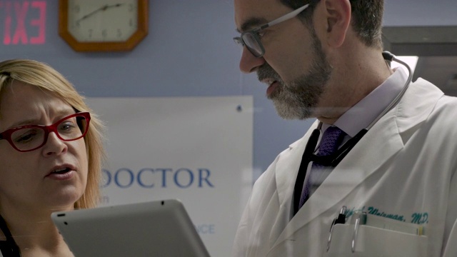 在一家现代医疗机构或医院里，两位医生正在看平板电脑