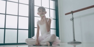 亚洲可爱的芭蕾舞者正在吃着西瓜形状的冰淇淋，情绪积极，心情放松，享受着吃股票视频