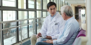 年轻的亚洲医生与年长的亚洲病人交谈