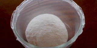 面包在用保鲜膜包裹的玻璃碗中发酵一段时间