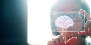 一名亚洲女性手持人类大脑的技术数字全息界面。人工智能的概念。