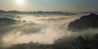 鸟瞰图的雾滚过流动在泰国北部的雨林山，Hyper lapse