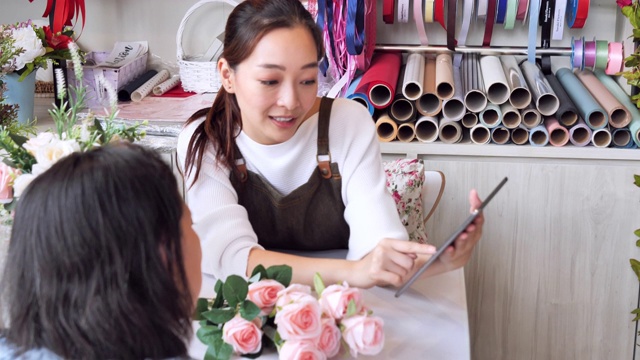 亚洲女人接到订单准备进店销售，日本女人拥有专业的花店，小的经营理念。