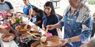 拉丁美洲的三代人在夏天一起吃家庭午餐