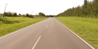 驾驶骑一辆汽车在一个乡村边的道路，山谷- POV板-观点前面