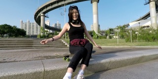 年轻的少女与滑板有乐趣在城市