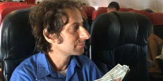 一位沮丧的旅行者在飞机上用现金买东西时遇到了困难