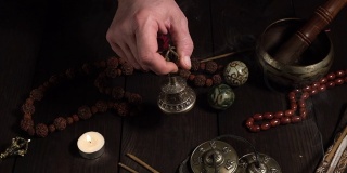 男性手持一个青铜仪式钟，用于祈祷和冥想